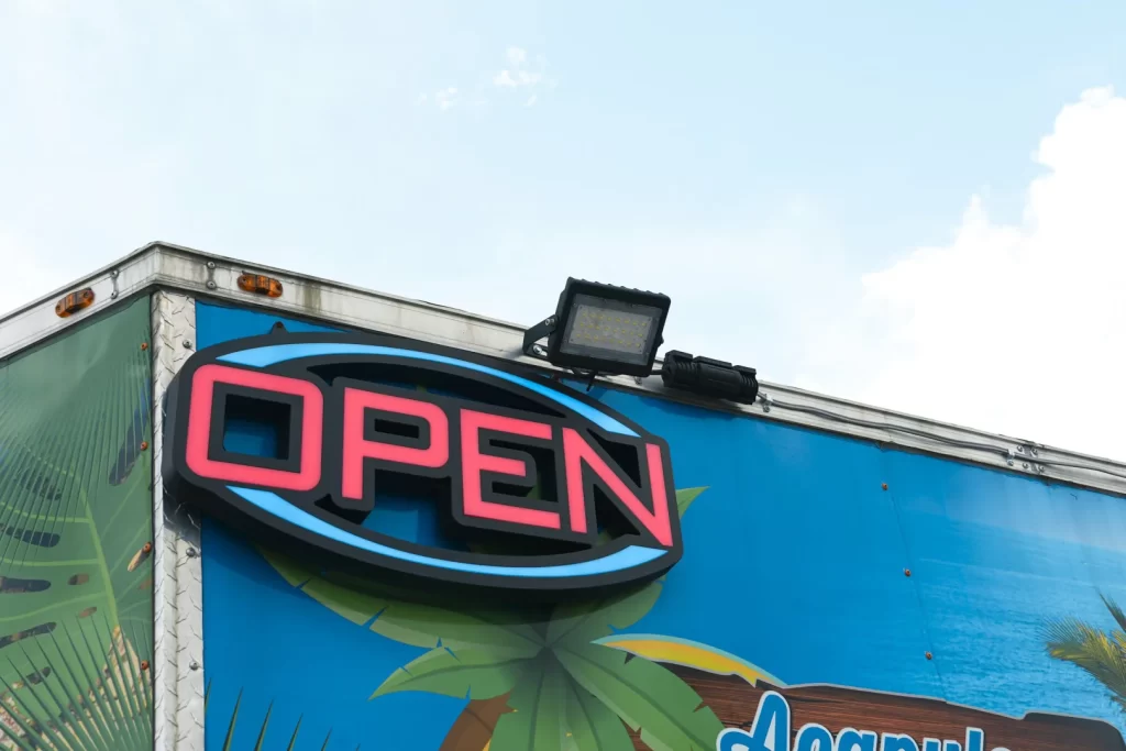 A prominent sign with the word ‘OPEN’ in large, visible letters, placed at the entrance indicating that you are ready to receive customers.