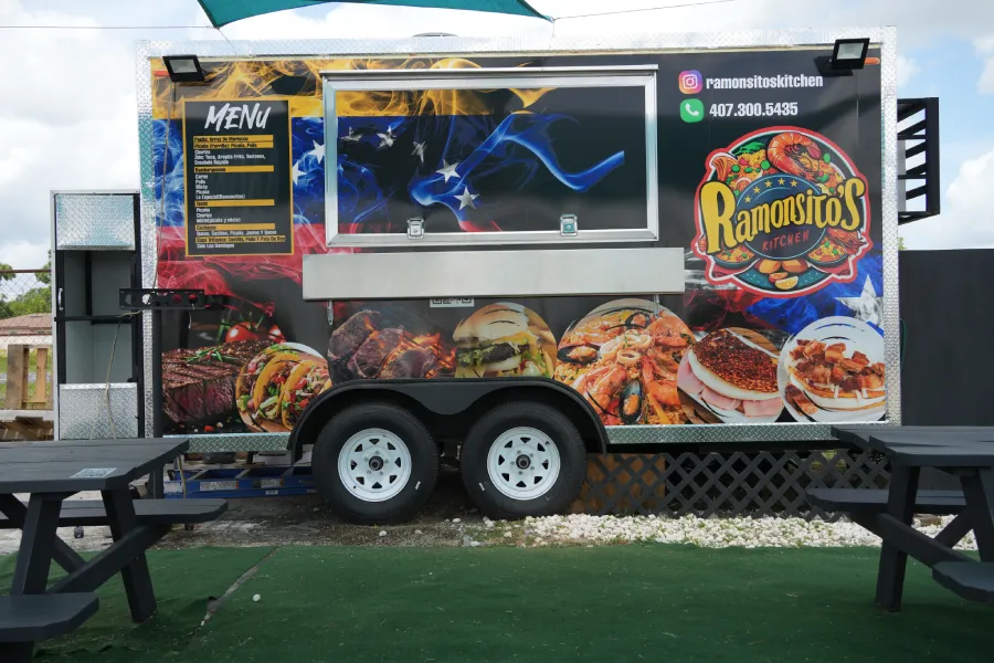 A dynamic food truck displays images on the truck itself showing a variety of culinary options that invite passersby to try the food available at this mobile eatery.